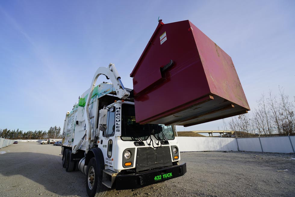 Hand pickup garbage removal truck in Edmonton collecting junk and waste